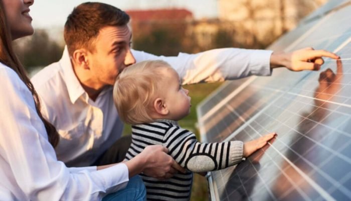 Familia observando las placas solares que ha instalado el grupo ecovida